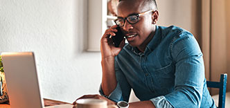Man in front of computer talking on phone
